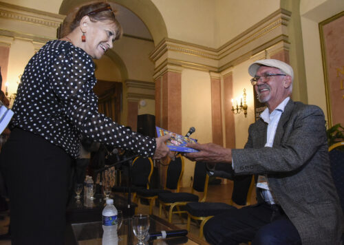 Aramís Acosta, productor de cine entrega libro a la actrís Mirtha Ibarra durante el 45 Festival del Nuevo Cine Latinoamericano